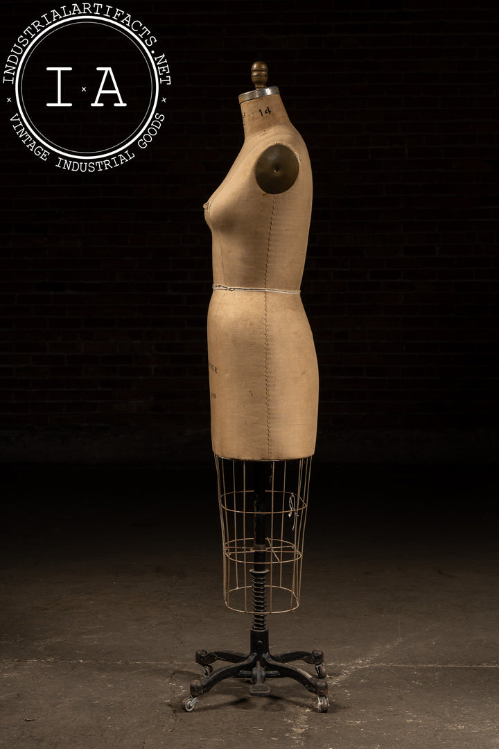 vintage dress forms 1960s JR Bauman Form A classic dress form with measuring tape stands beside an elegant chair draped with fabric against a textured wall Antique Black Dress Form #Bdp